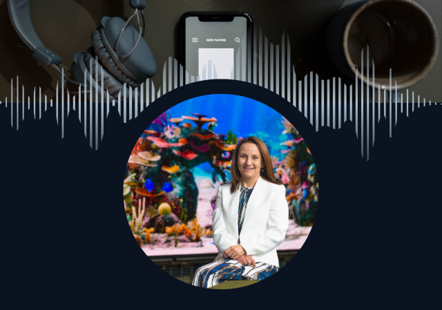Professor Kerrie Wilson sitting in front of a fish tank